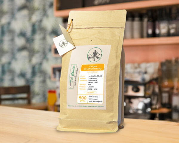 Bolsa de café de especialidad peruano origen Chanchamayo de 500 gramos, Café del Camino, 100% arábico, sobre mesa de cafetería.